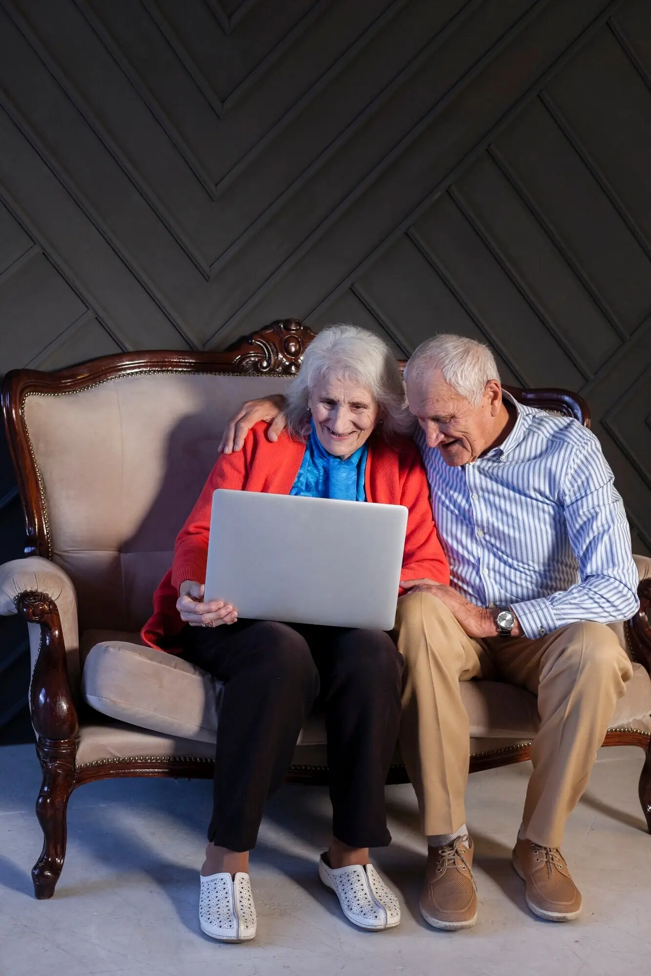 Frontalansicht eines älteren Paares, das einen Laptop benutzt.